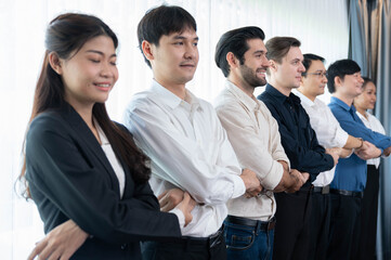 Obraz premium Business team standing, join and link hand together in line symbolize successful business partnership and professional synergy with diverse culture group people cooperation. Prudent