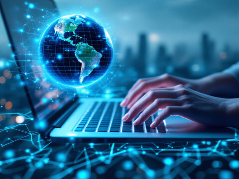 A person typing on a laptop with a holographic globe above the keyboard, symbolizing global digital connectivity.