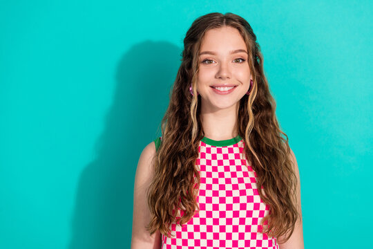 Photo of lovely young girl beaming smile empty space wear checkered dress isolated on teal color background