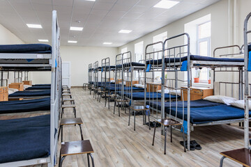 Fototapeta premium Empty dormitory room with bunk beds and wooden flooring