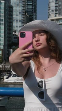 Beautiful Young Woman Takes a Selfie While Standing on a Rooftop. High quality 4k footage