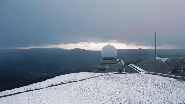 Snow-Covered Radar Dome on Mountain Summit