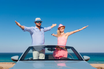Happy couple in love travel by car by the sea