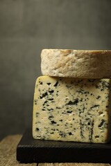 Fresh cheese on wooden table against grey background, closeup