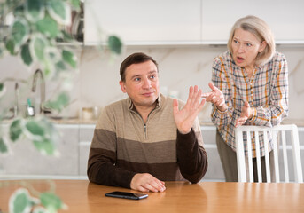 Family quarrel, mother blaming son, both are upset, angry and disappointed