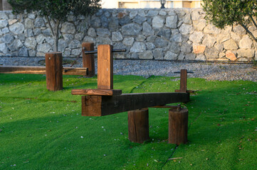 Unique wooden fitness equipment nestled in a serene outdoor park setting under the morning sunlight