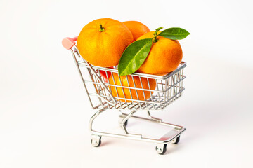 Tangerines with leaves in a trolley from a market on a white background