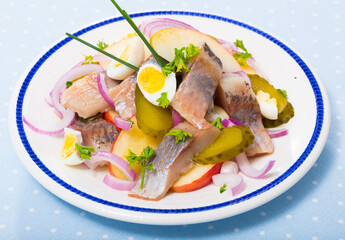 Traditional Norwegian dish - Salad Herring with apples, pickles, and quail egg