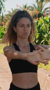 Fit athlete woman making stretching exercises open air tropical park. Female student goes in for sports before classes at university. Active Fighting hypodynamia and stress.