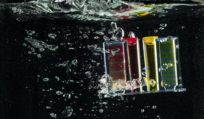 PH acid level test kit on quality water on screen. PH acid level tester kit tools fall under water splashing splattering with air bubble over black background isolated