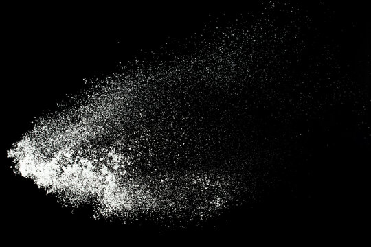 Fluffy White snow splash flying or throwing in mid air. Snowfall on Black background isolated. Snow dust element falling over dark night