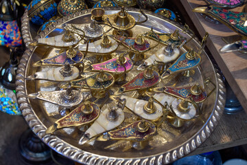 Small decorative oil lamps displayed in a souvenir shop in Marrakech.