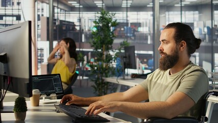 System administrator with disability in inclusive workspace training machine learning models. IT...