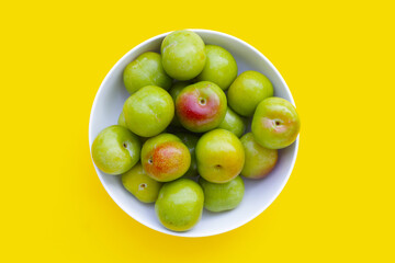 Fresh green plum on yellow background