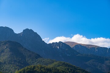 Mountains under a clear blue sky with slight cloud coverage in a serene natural landscape