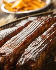 Fototapeta premium Barbecue Ribs with French Fries and Coleslaw on Rustic Fur Background