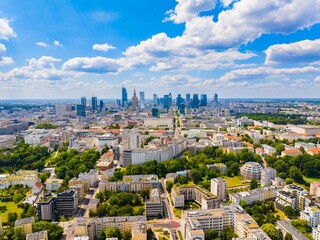 Skyline view of Warsaw showcasing modern architecture and green spaces under a bright blue sky