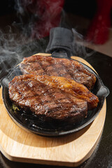 Assorted Cuts of Raw Meat with Knives, Charcoal, and Herbs on Rustic Background