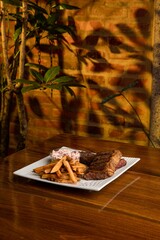 Assorted Cuts of Raw Meat with Knives, Charcoal, and Herbs on Rustic Background