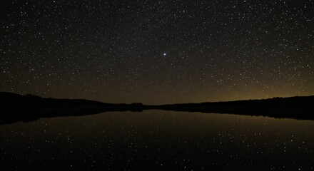 Fototapeta premium A field of stars reflected on a perfectly still, black mirror-like lake