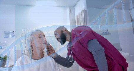 Image of dna strand rotating over diverse male doctor checking ear of senior female patient