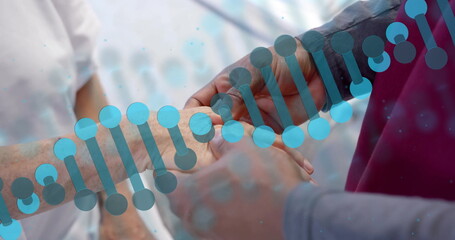 Image of dna strand rotating over diverse male doctor massaging hand of senior female patient