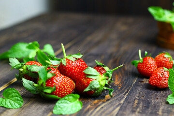 Fresh strawberry fruits and mint leaves on wooden  rustic background.