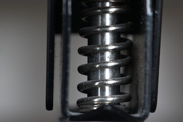 Close up of steel spring around metal pin
