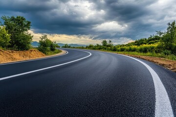 Fototapeta premium A long straight road through beautiful fields with trees along the road and wide open horizons.