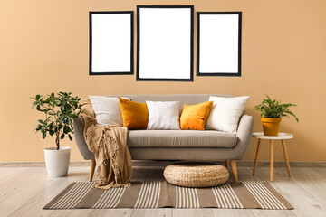 Interior of living room with grey sofa and rattan pouf
