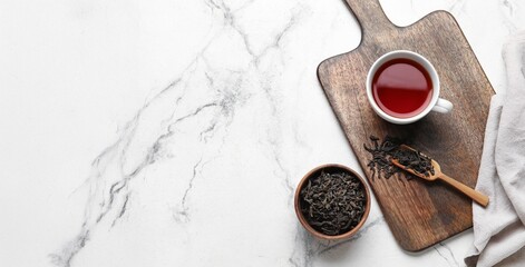 Composition with hot tea and dry leaves on marble background with space for text, top view