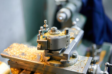 Precision engineering in action with a small-sized lathe crafting intricate metal parts in a workshop setting