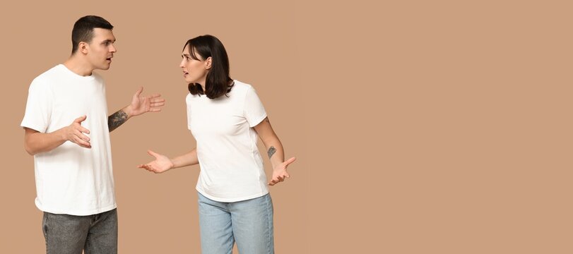Quarrelling young couple on beige background with space for text