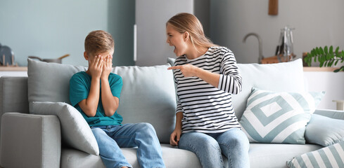 Angry mother scolding her son at home