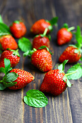 Fresh strawberry fruits and mint leaves on wooden  rustic background.
