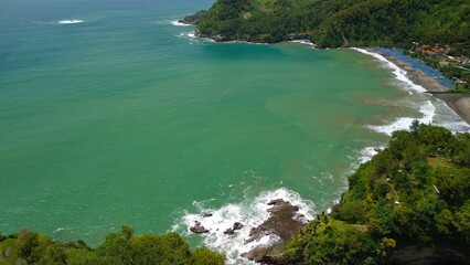 Aerial drone view of coastline with hills and trees, as well as view of coral cliffs and sea with waves from the ocean in Watu Bale  Beach Kebumen Central Java Indonesia