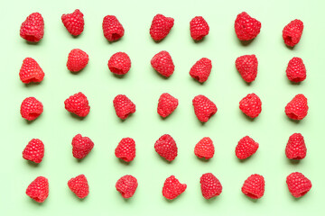Many fresh raspberries on green background