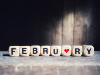 Obraz premium February word on wooden cubes in retro style background. Stock photo.