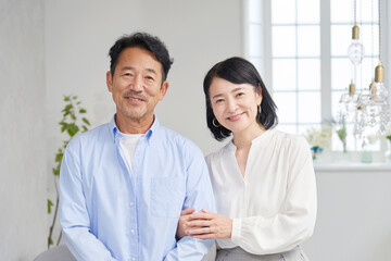 中年夫婦のポートレート　リビング　カメラ目線