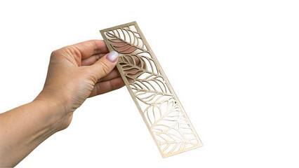 A hand holding an intricate metal bookmark with a leaf design, perfect for nature lovers and avid readers.