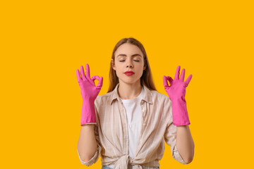 Beautiful young housewife meditating on yellow background. Zen concept