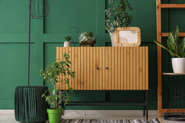 Wooden cabinet with ladder and lamp near green wall