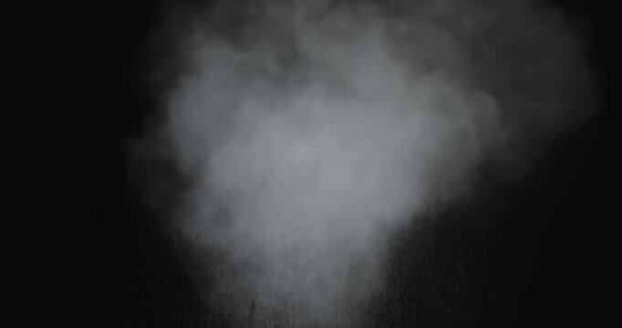 4K VFX practical element slow-motion close-up of dust explosion from bullet hitting the black wall. A dense powder explosion occurs against a black background action element. Gunshot impact on black