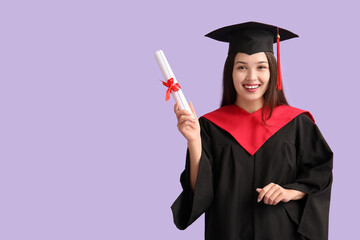 Young female graduate with diploma on lilac background