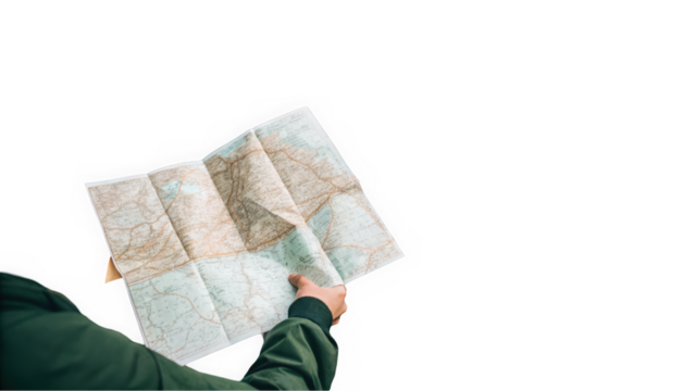 A person holding an unfolded map, exploring routes and destinations for adventure, dressed in a green jacket.