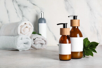 Bottles of natural cosmetics on light background