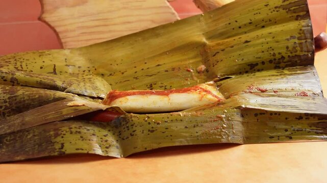 Tamal de masa cocida o tamal de veracruz sobre plato de barro en cocina mexicana 