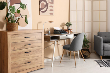 Stylish workspace with vintage typewriter, cup of coffee and books in living room
