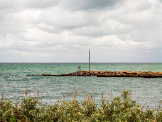 Precariously Stepping On Rocks Above Sea