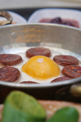 fried egg mixed with sausage on a plate 